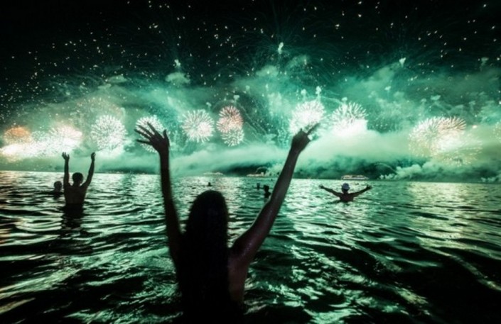 "Celebrating New Year 2014-People watch the fireworks across the water at Copacabana beach"