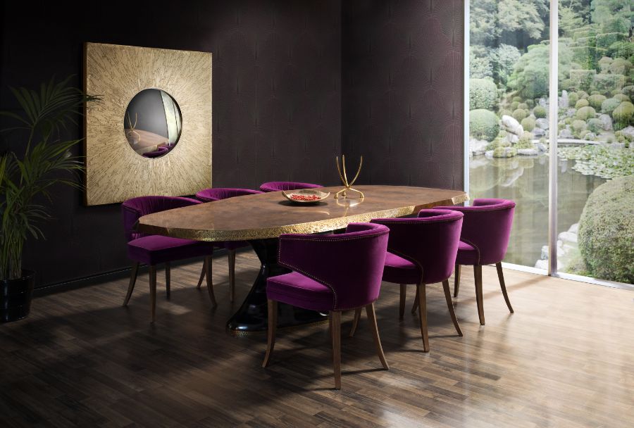 dining room with pink velvet dining chairs, oval wood dining table and decorative wall mirror
