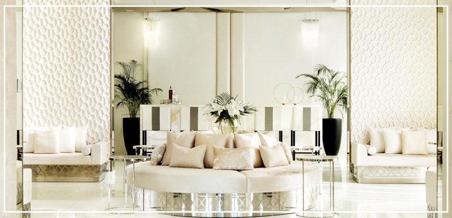 White living room with a round center sofa with metal details complemented with a bespoke design.