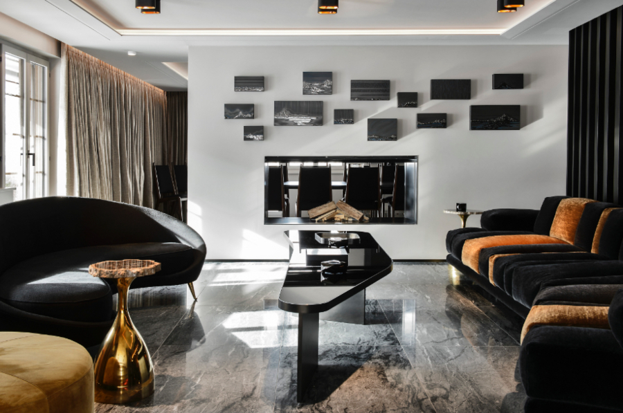 Thierry Lemaire: Modern Living Room Decor. Black and gold living room, the colours that most reflect luxury and power. Combined with the marble floor and a fireplace built into the wall, this living room becomes a modern and welcoming environment.