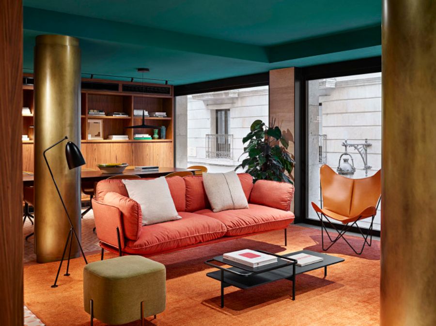 living room with red sofa, orange armchair, black coffee table, black floor lamp, orange rug