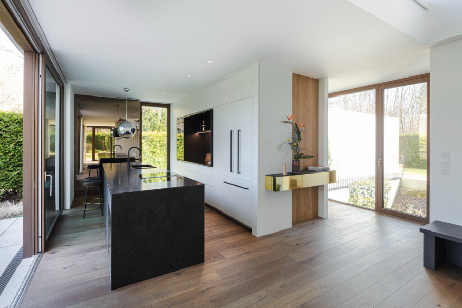 open spaceopenspace kitchen with ssuspension lights and a black island in the middle of the kitchen.