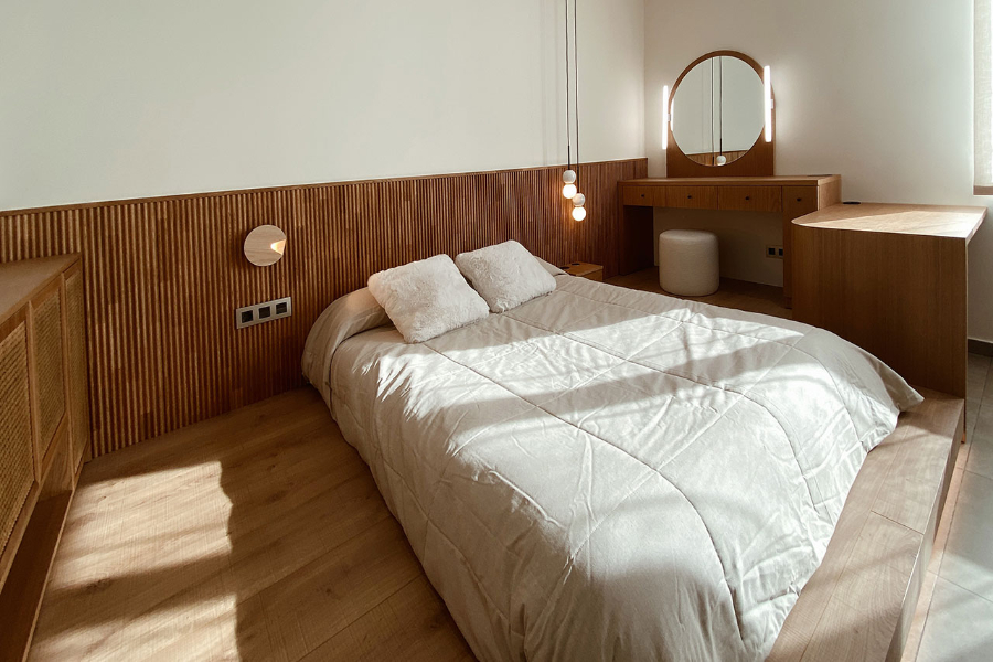 Suite by Franquet Barrau with wooden headboard, wooden vanity and oval mirror